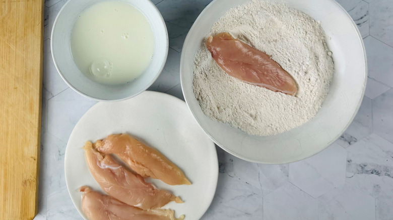 Chicken dredging station with chicken tender in flour