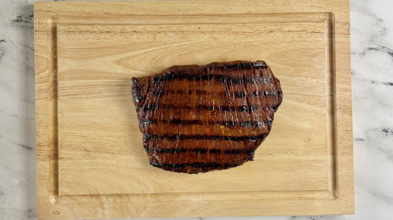 cooked steak on a wooden board