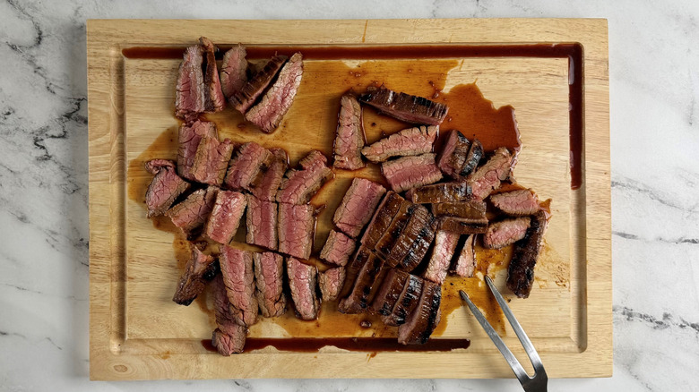 chopped cooked steak on a wooden board