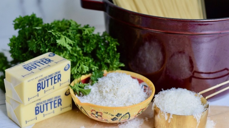 butter, parsley, cheese, and pasta in a pot