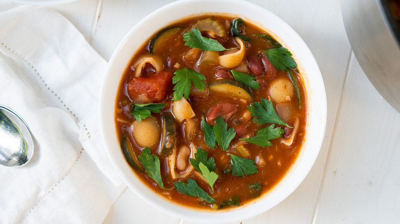 bowl of minestrone soup with parsley garnish