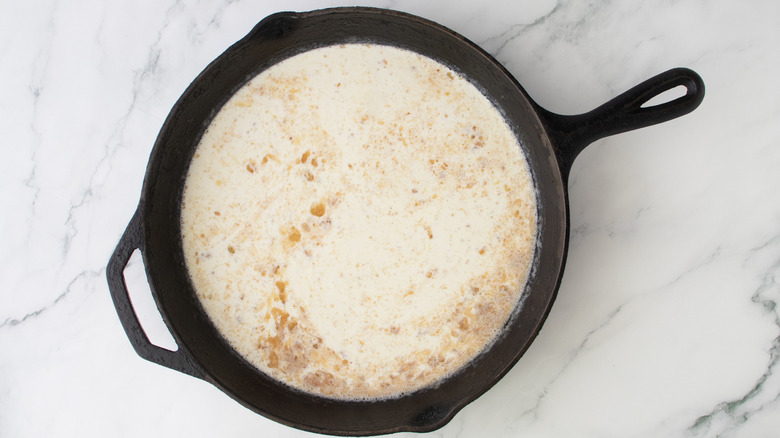 creamy sauce in a black frying pan