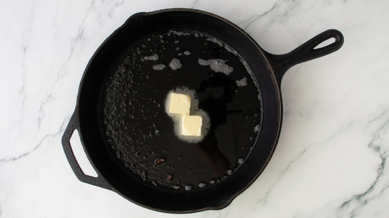 chunks of butter in a black frying pan