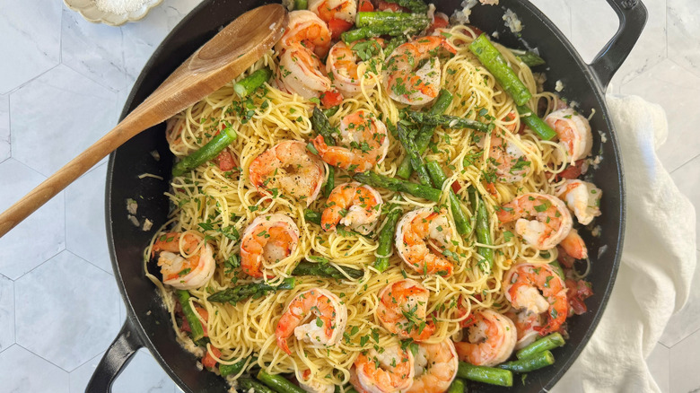 Shrimp scampi with asparagus and pasta in a large pan