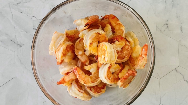 Cooked shrimp in glass bowl on marble surface