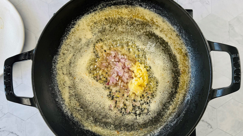 Melted butter in large pan with diced garlic and shallots in the center
