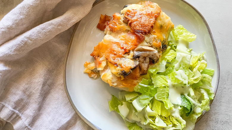 alice springs chicken on white plate with side salad and napkin