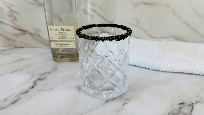 drinking glass with a black salt rim in front of a folded towel