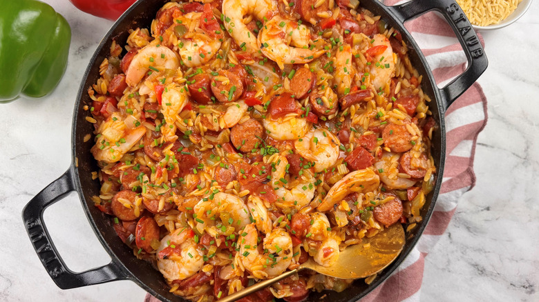 shrimp, sausage, and tomato stew in a black pot