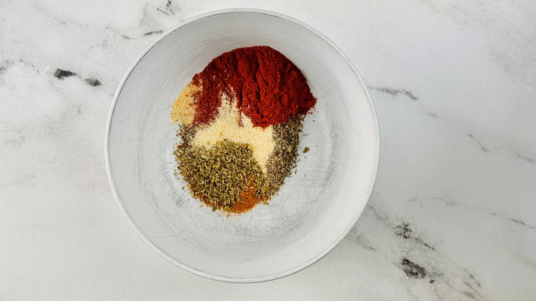 assorted herbs and spices in a white bowl