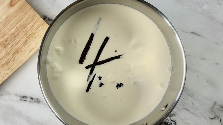 Cream and vanilla beans in saucepan
