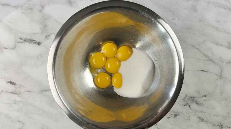Egg yolks and sugar in bowl