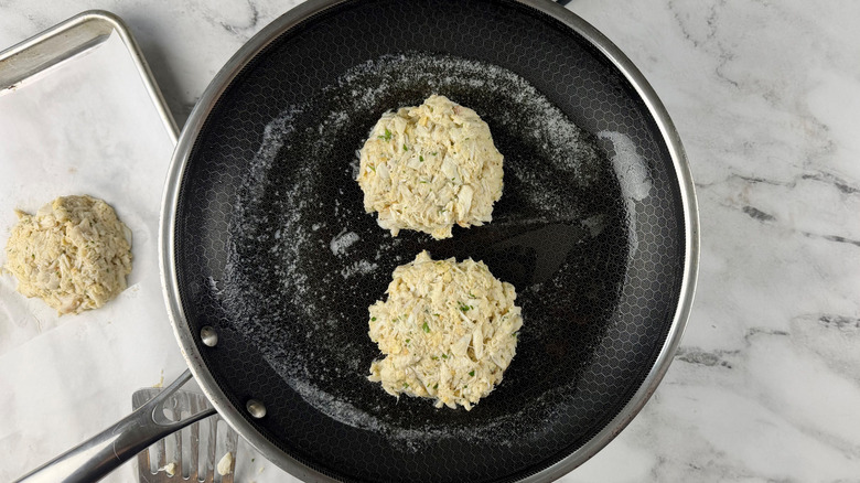 Crab cakes cooking in pan