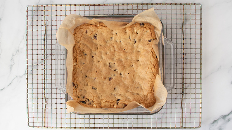 uncut bar cookie in a square pan on a wire rack