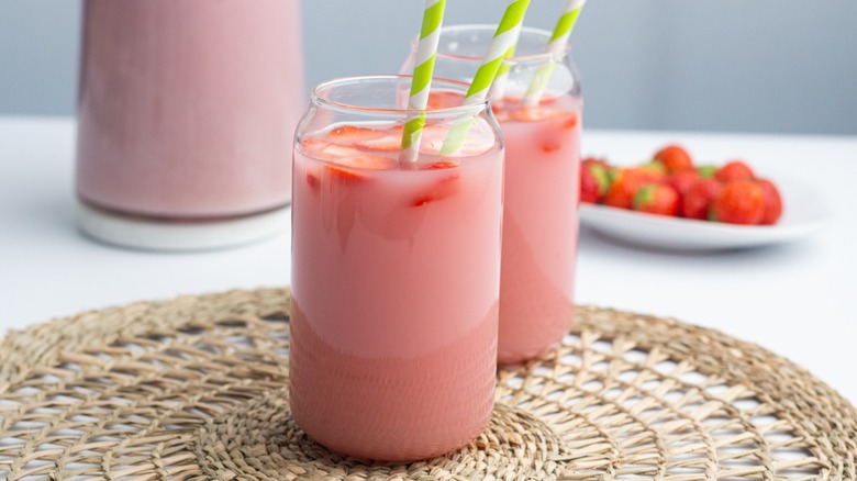 Copycat Starbucks pink drink on a table with a pitcher and strawberries