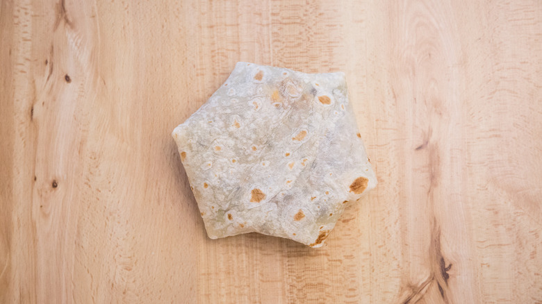 uncooked Crunchwrap on wooden table