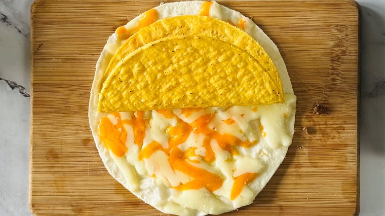 flour tortilla topped with melted cheese and a taco shell