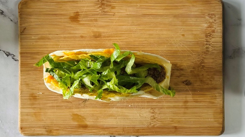 tortilla-wrapped taco with ground beef and lettuce