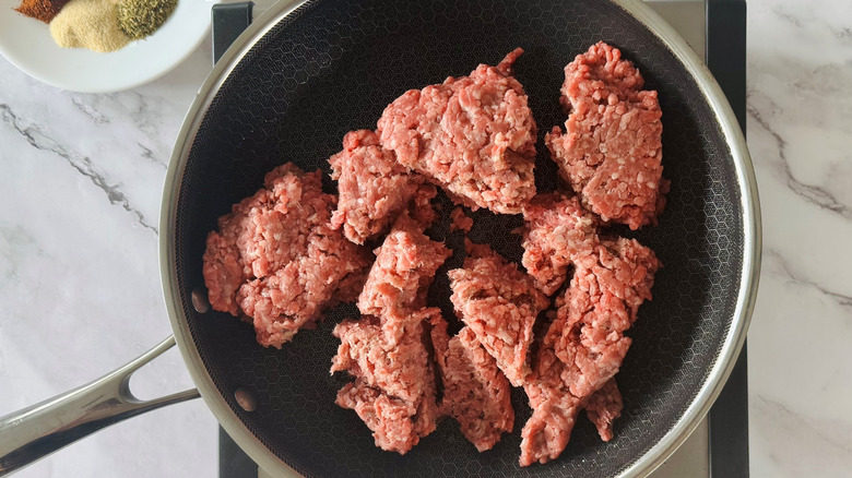 uncooked ground beef in a frying pan
