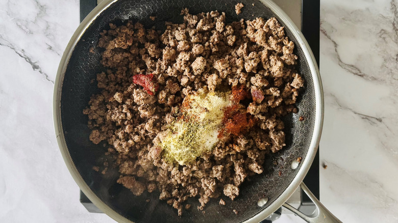 cooked ground beef and spices in a frying pan