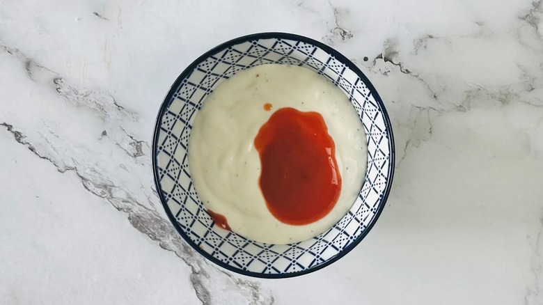 bowl of white creamy substance with red liquid on top
