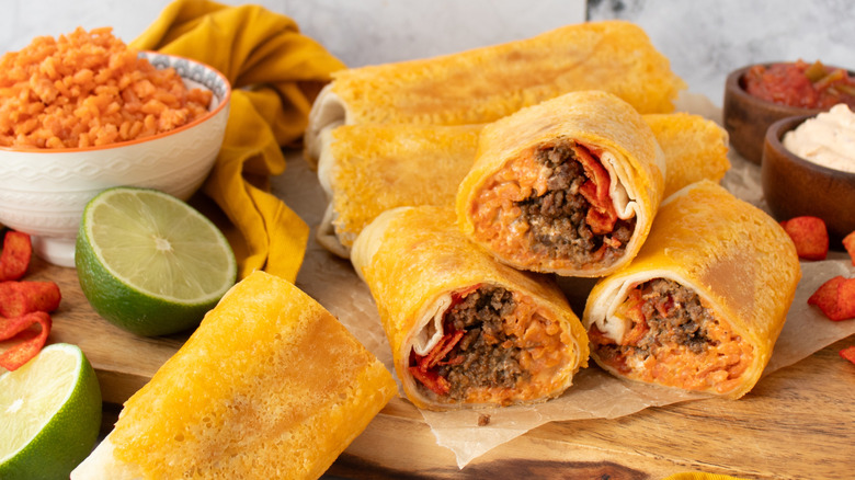 orange-colored burritos on a wooden board