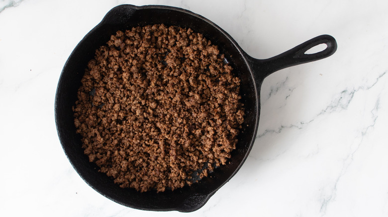 cooked ground beef in a black frying pan