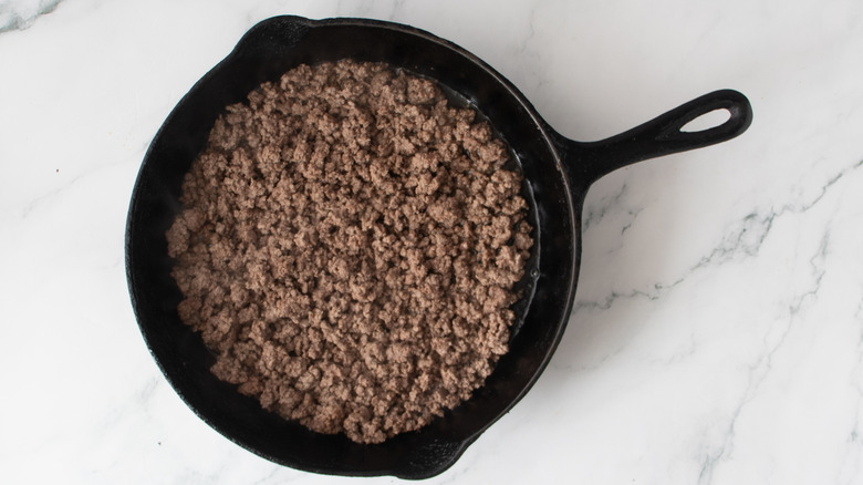 cooked ground beef in a black frying pan