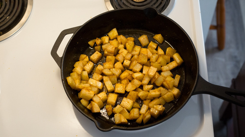 cubed potatoes in iron skillet