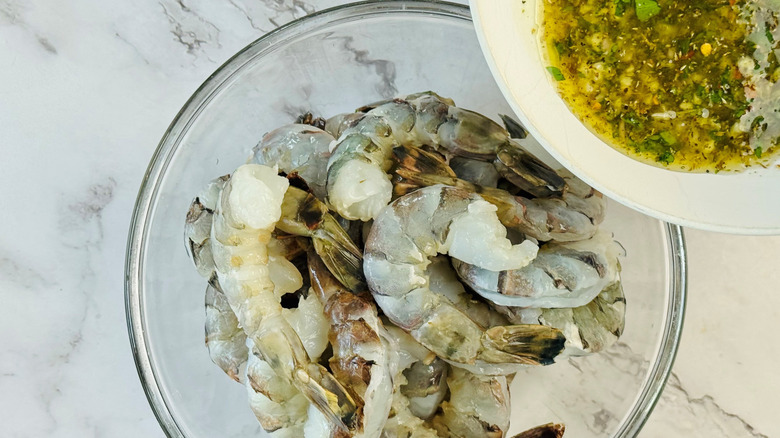 pouring marinade over shrimp in bowl