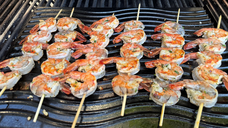 skewered shrimp cooking on grill