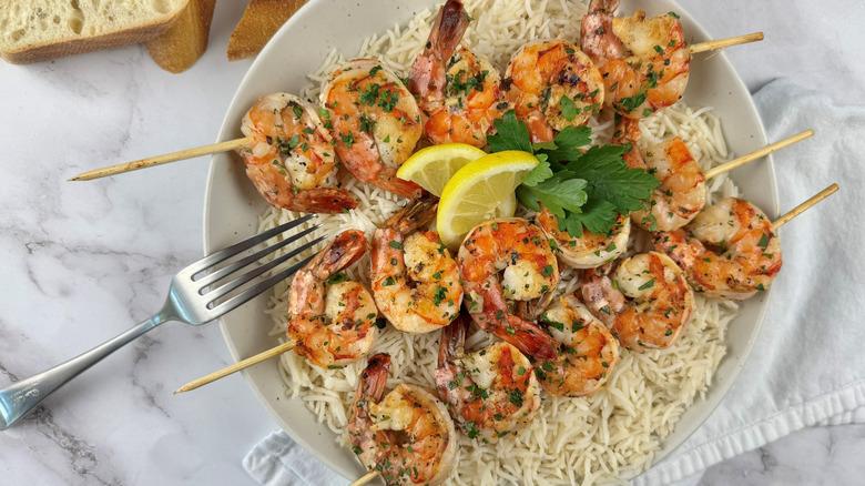 grilled shrimp skewers and rice on plate