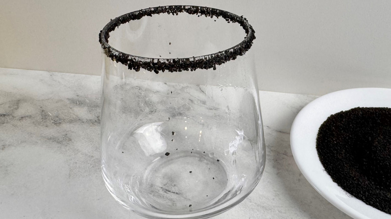 drinking glass rimmed with black salt