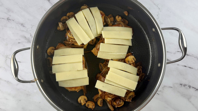 Chicken with mushrooms and cheese in pan