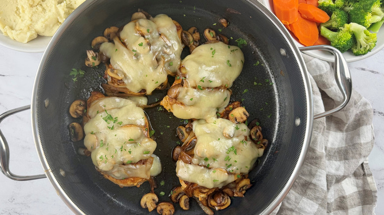 Chicken with mushrooms and melted cheese in pan