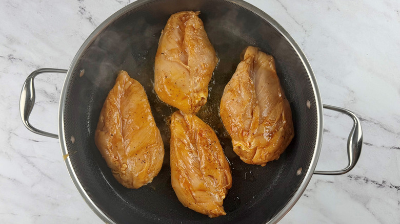 Chicken breasts cooking in pan