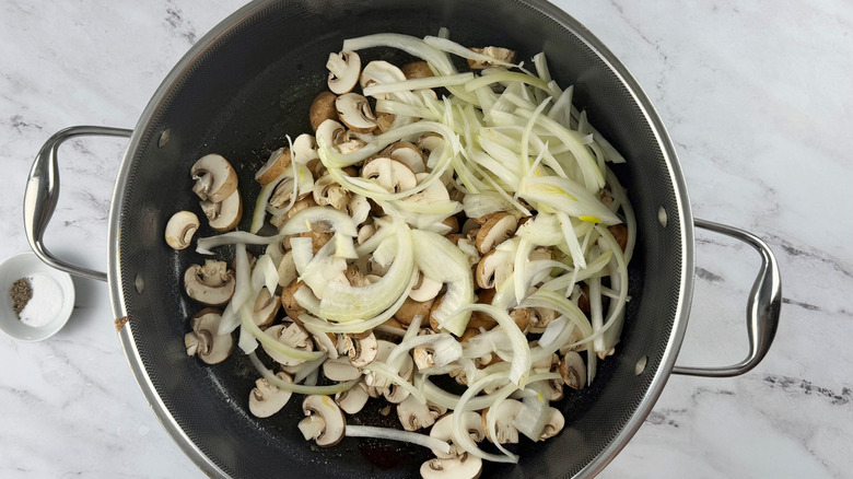 Sliced onions and mushrooms in pan