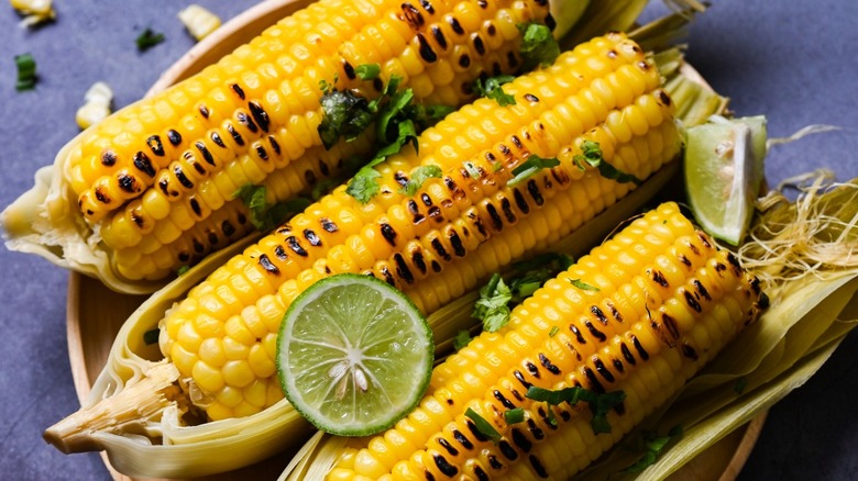 Grilled corn on the cob with herbs and lime 