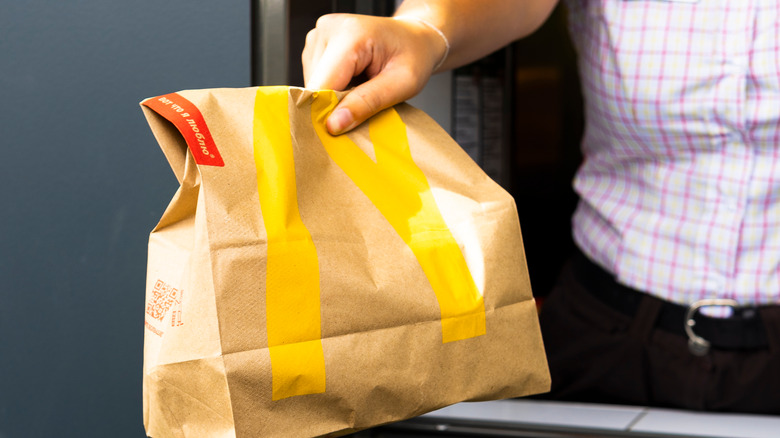 Worker passing McDonald's bag 