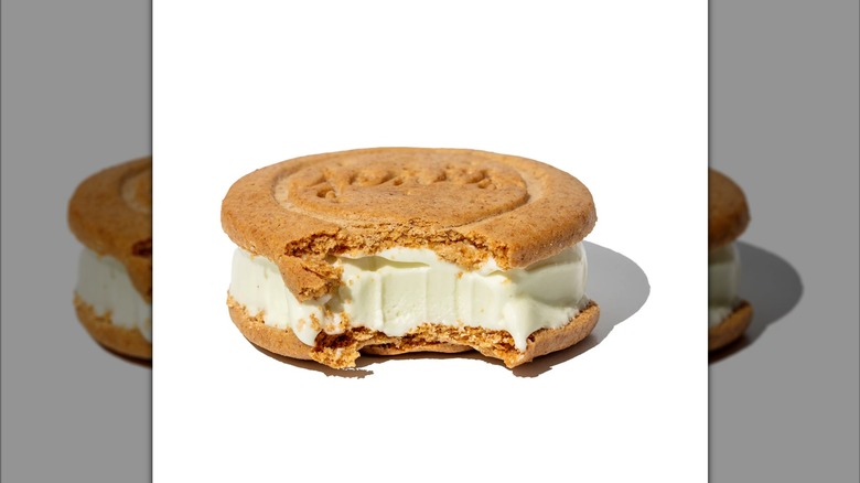 Jeni's Ice Cream cookie sandwich in key lime pie flavor with a bite taken out of one side.