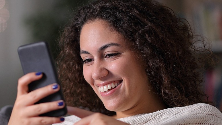 Woman laughing at a phone