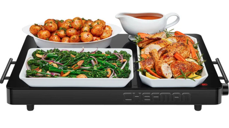 Warming tray with plates of food and gravy boat