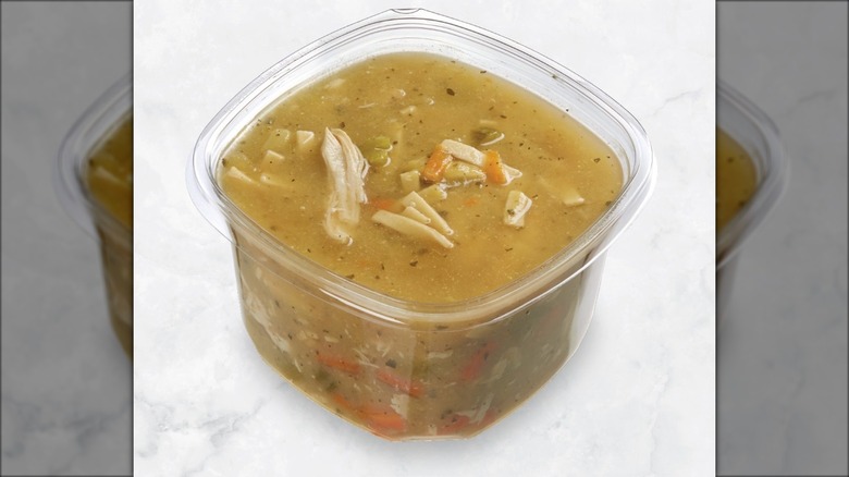 Open plastic tub with Costco chicken noodle soup