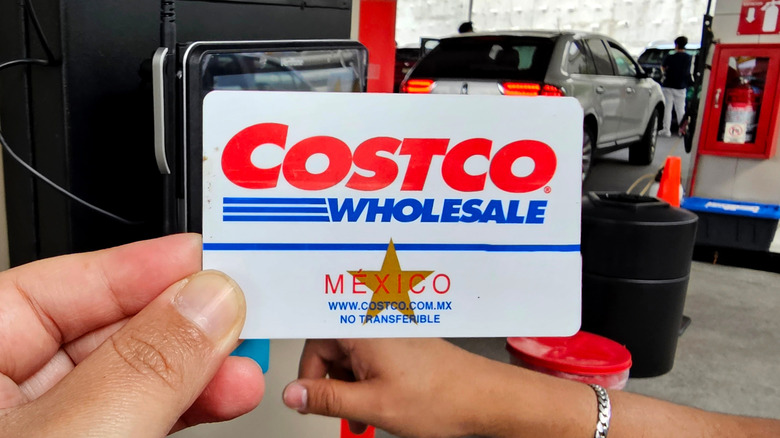 Hand holding Costco Mexico membership card at Costco gas station.