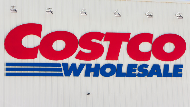 The Costco sign hanging on white building