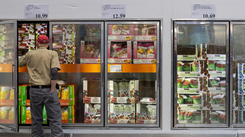 Customer looking at frozen foods in Costco aisle.