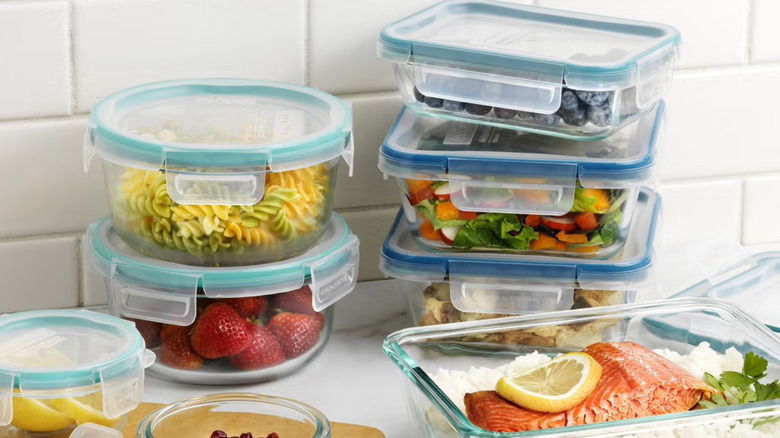 Stacks of full Snapware Pyrex food storage containers in white kitchen.