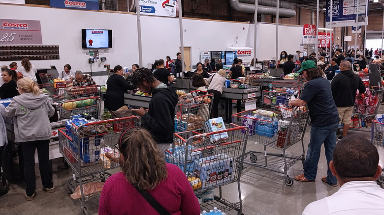 Shoppers waiting in line inside busy Costco.