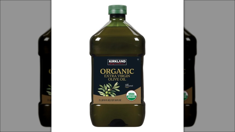 2-liter bottle of Kirkland Signature organic extra-virgin olive oil against white background.
