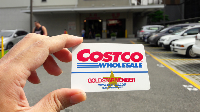 a hand holding a costco card